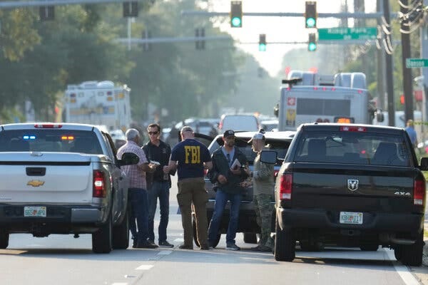 Law enforcement officials stand in front of a traffic light near the scene of a mass shooting in Jacksonville, Fla.