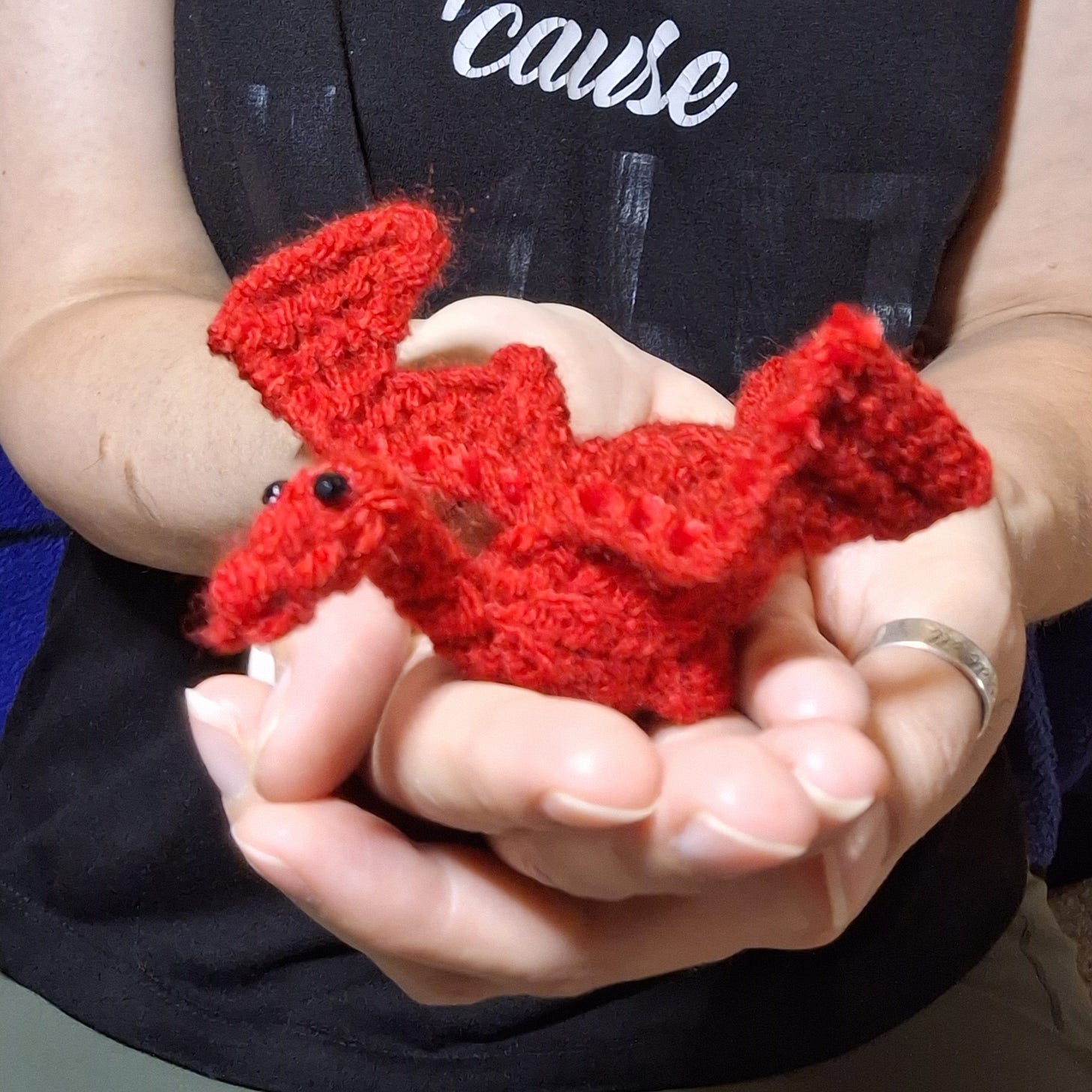 image of a handmade knitted red dragon. made by fantasy author patricia j.l. read more to learn how to make the dragon yourself.