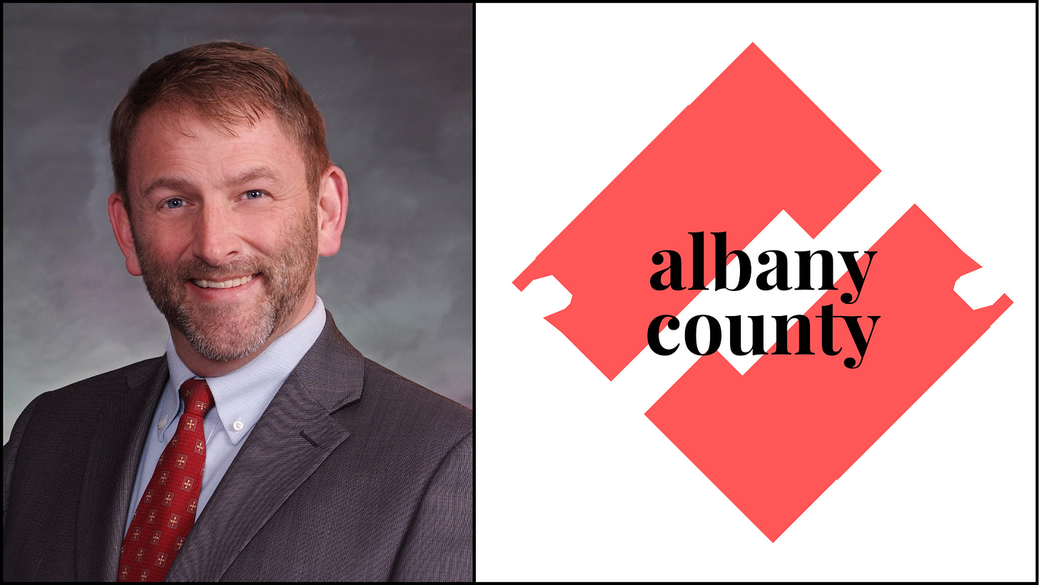 Rothfuss' official portrait aside a stylized graphic logo for Albany County.