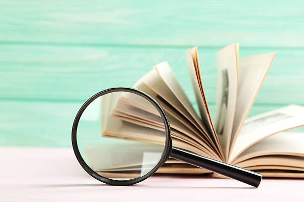 Magnifying glass on a pink wooden table Magnifying glass on a pink wooden table mystery book stock pictures, royalty-free photos & images