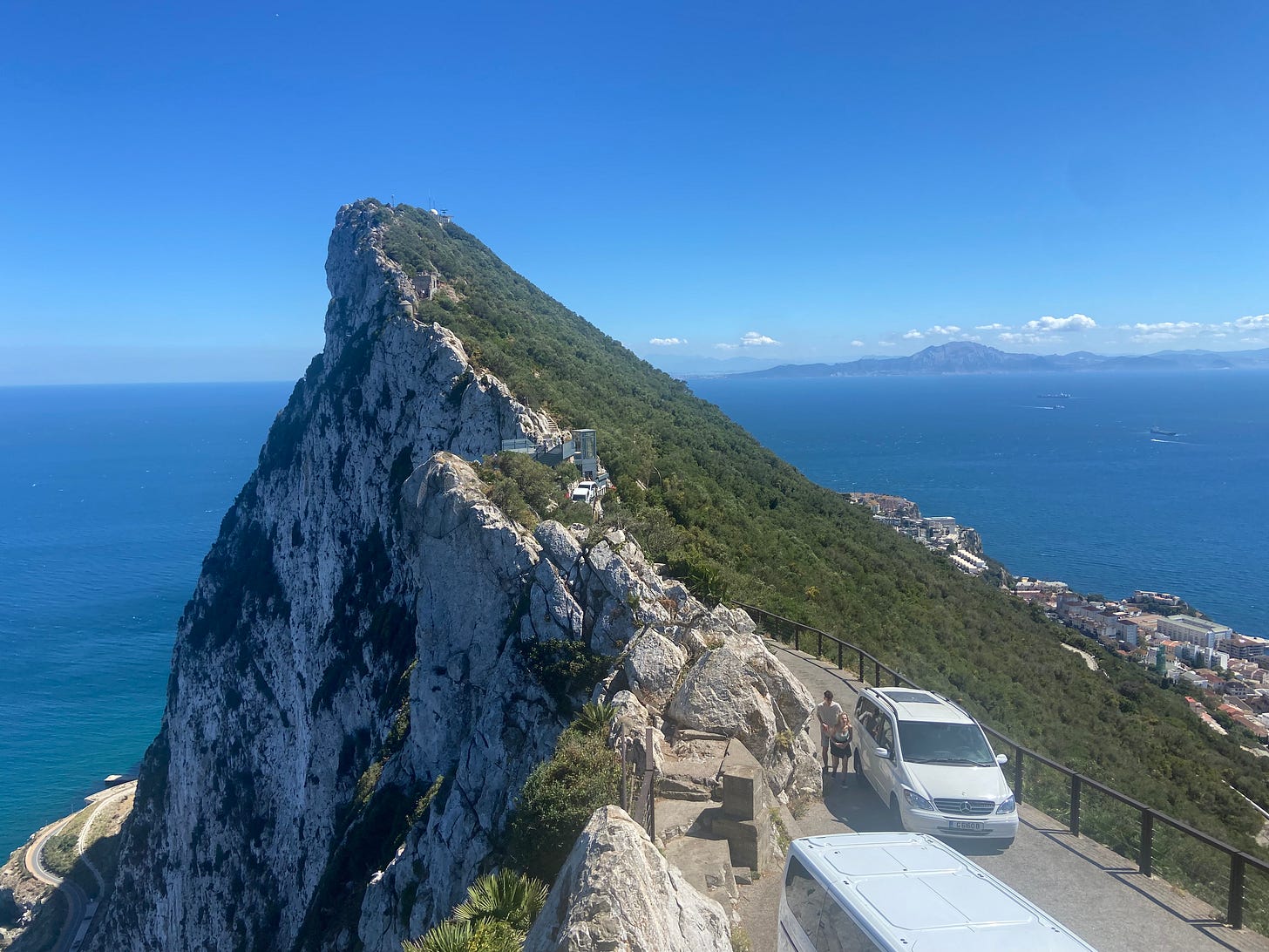 A mountain top looking out over the horizons at mountains in the distance.