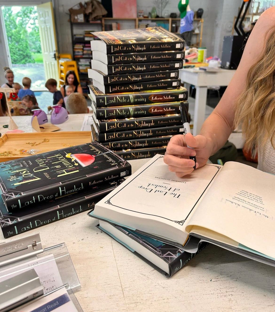 novelist Katharine Schellman signs copies of The Last Drop of Hemlock, The Last Note of Warning, and Last Call at the Nightingale