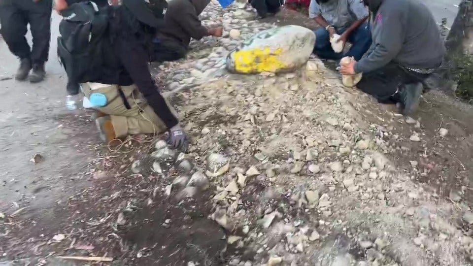 People gathering rocks and debris during a riot.