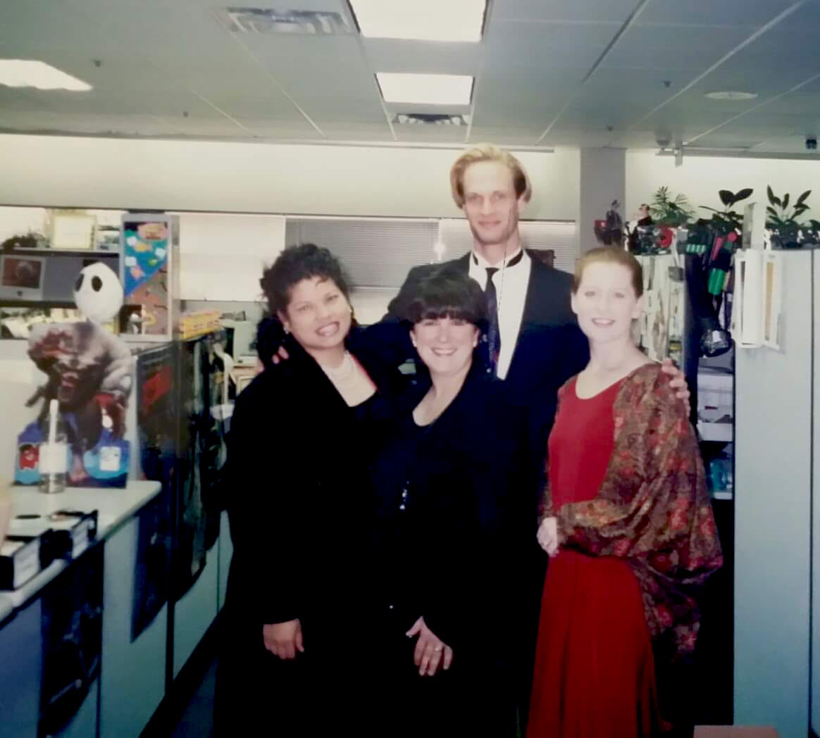 A photograph of the Wizards of the Coast Sales Team from around 1996: Lee Johnson, Ellie Haguel, Jim Atkiss, and Carol Monahan