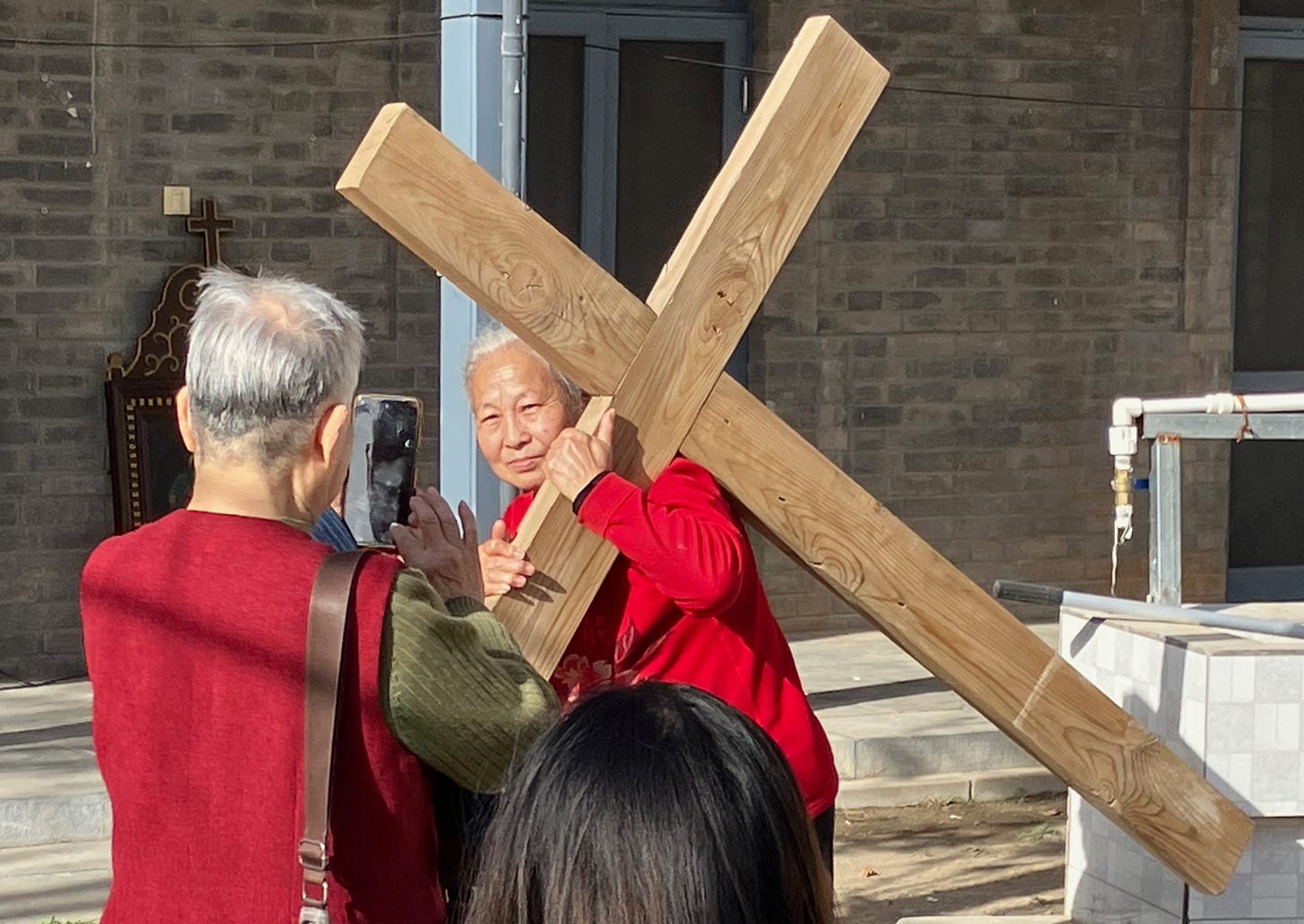 Laypeople take turns testing the feeling of carrying a cross on Good Friday at South Church.