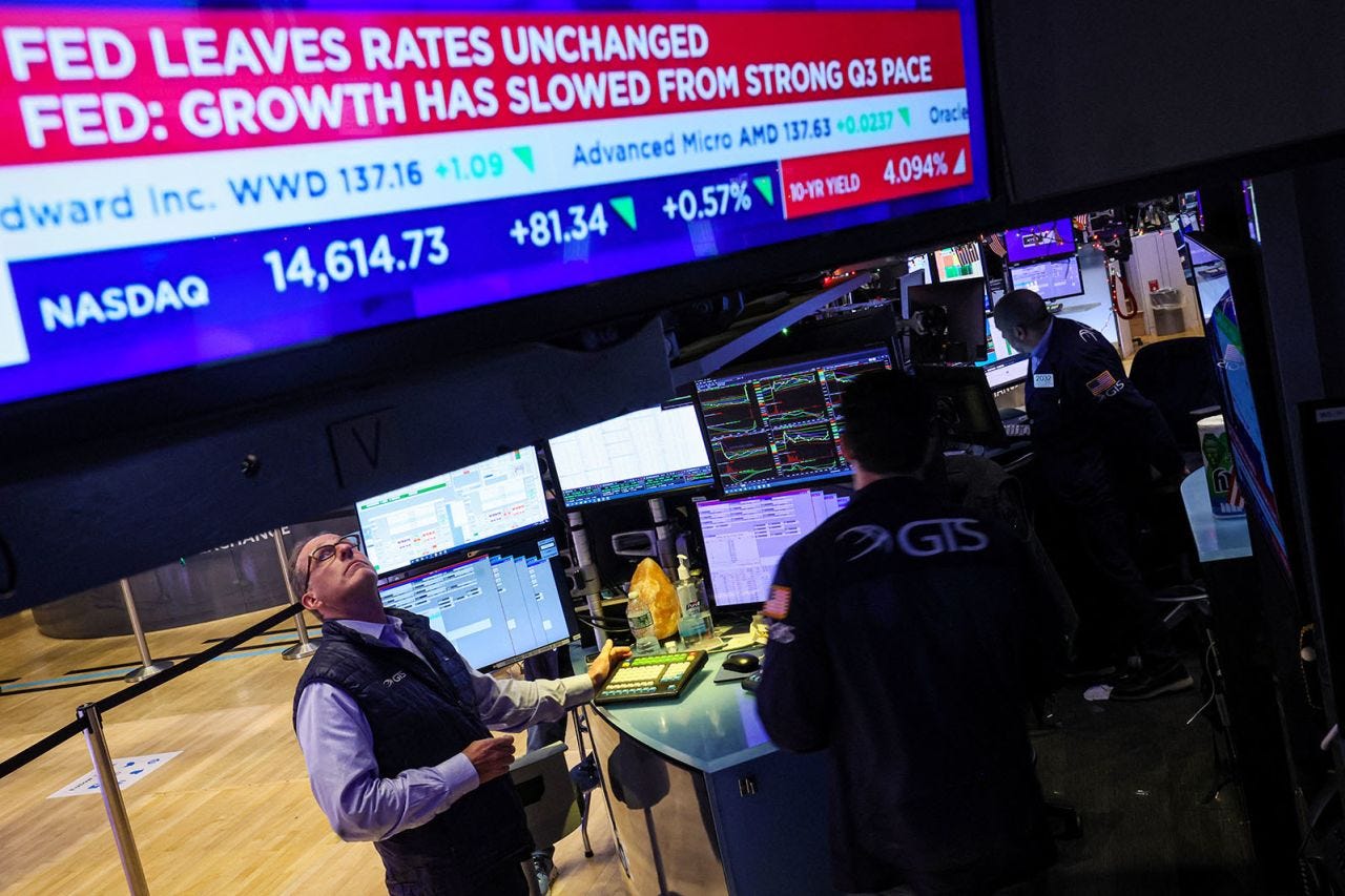 Traders react as a screen displays the Fed rate announcement on the floor of the New York Stock Exchange on December 13.