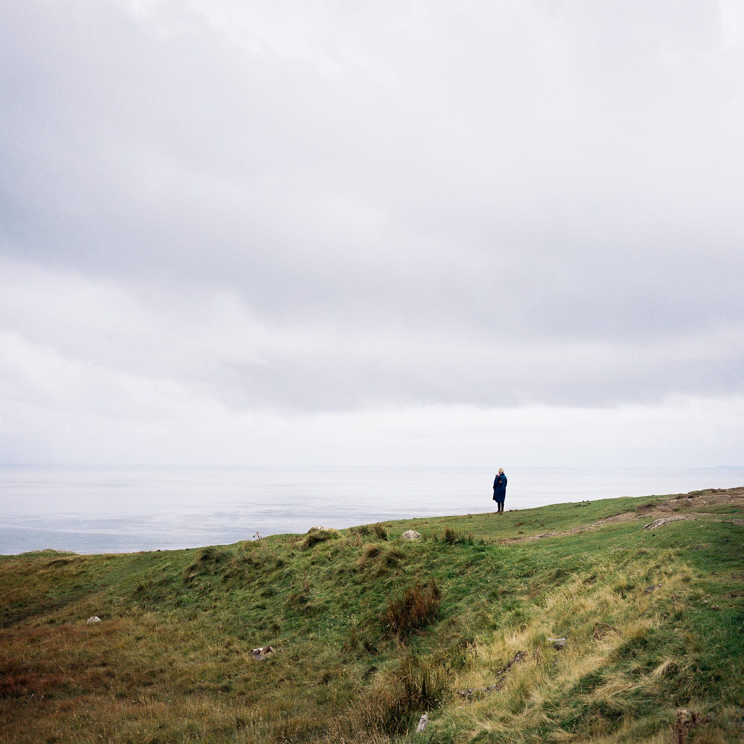 Photo of woman standing alone cliffside