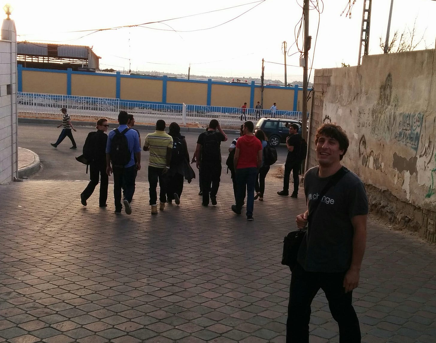 People walk down a driveway in Gaza at sunset