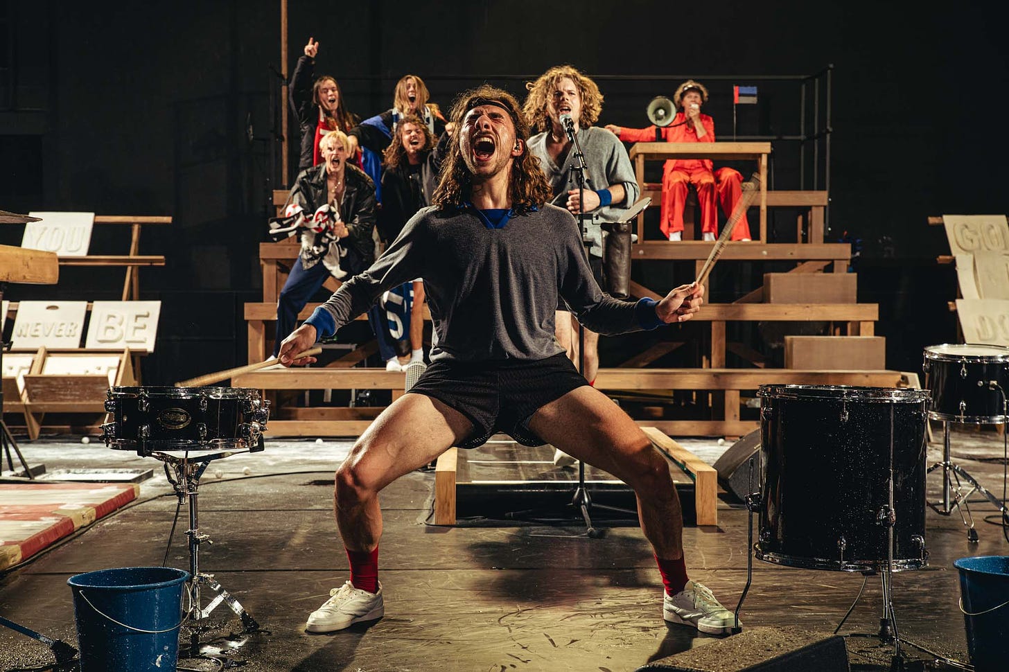 A photograph of One Song showing a performing screaming and drumming