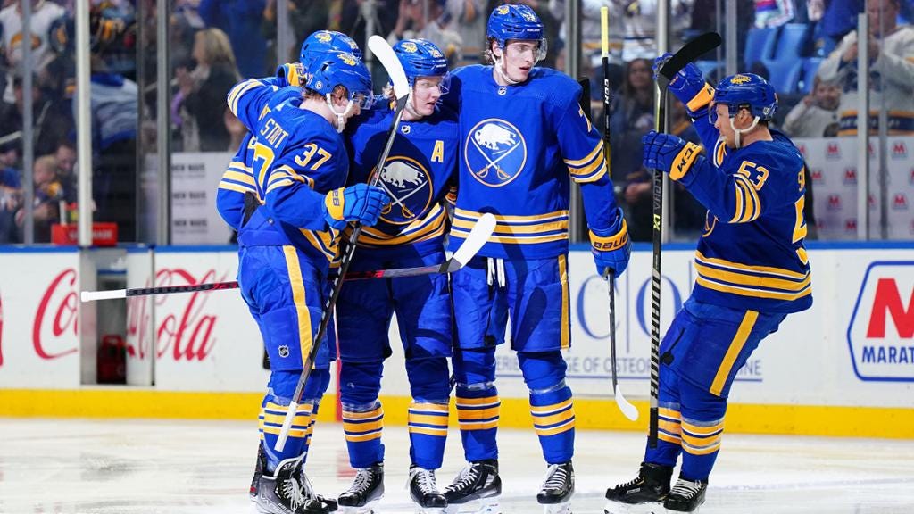 Buffalo Sabres players celebrating together after a goal was scored.