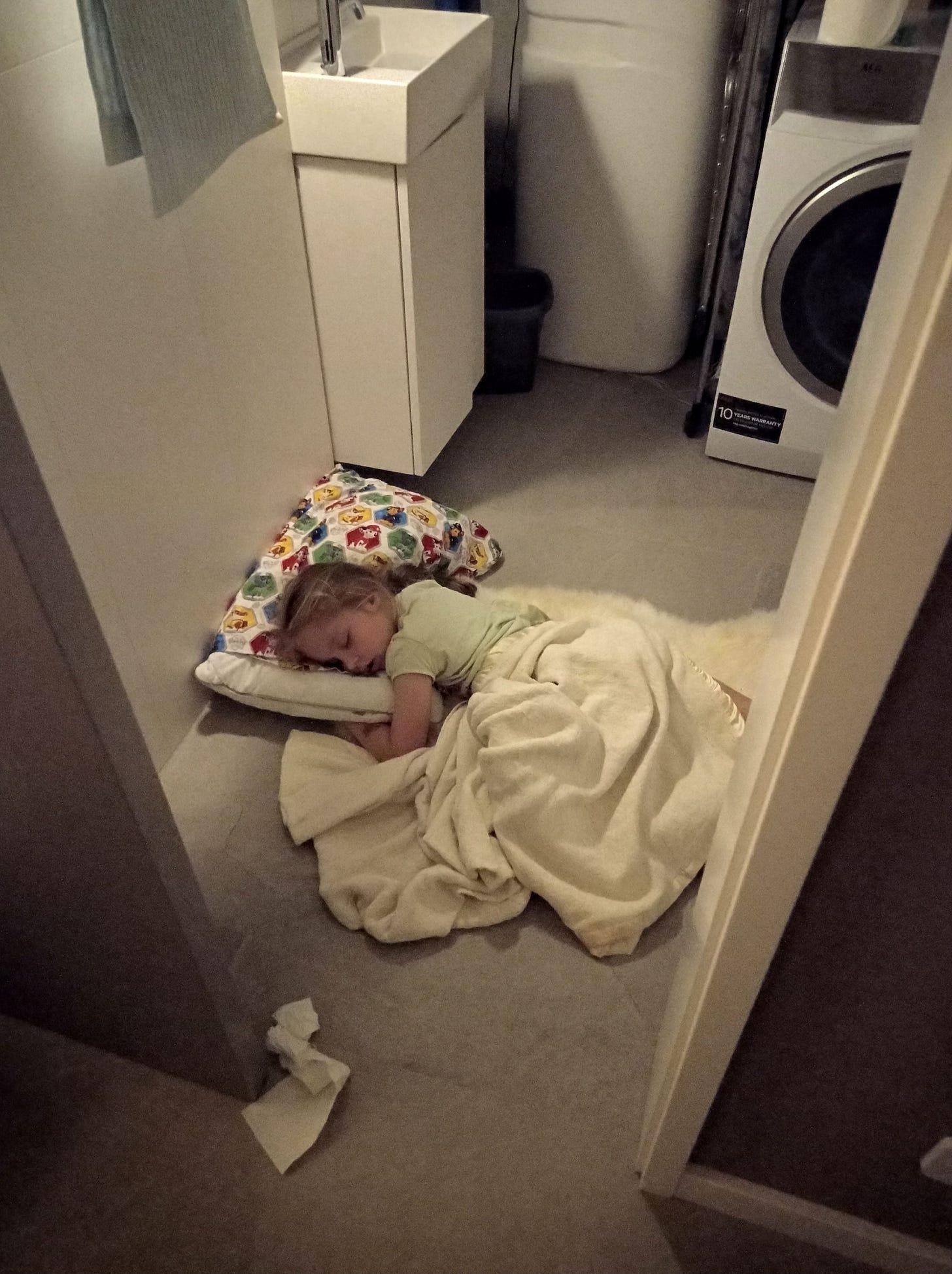 A little girl sleeps on the bathroom floor during an air raid in Ukraine.