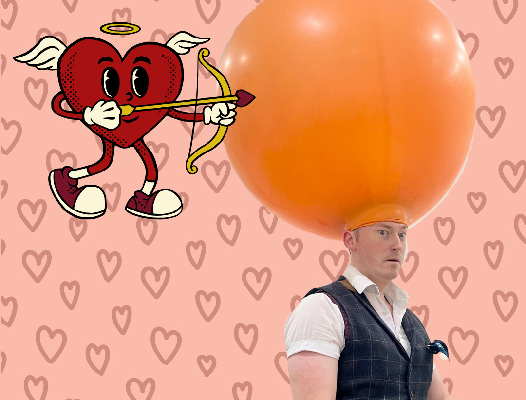 man with large balloon on his head. Cartoon of heart cupid firing arrow towards the balloon.