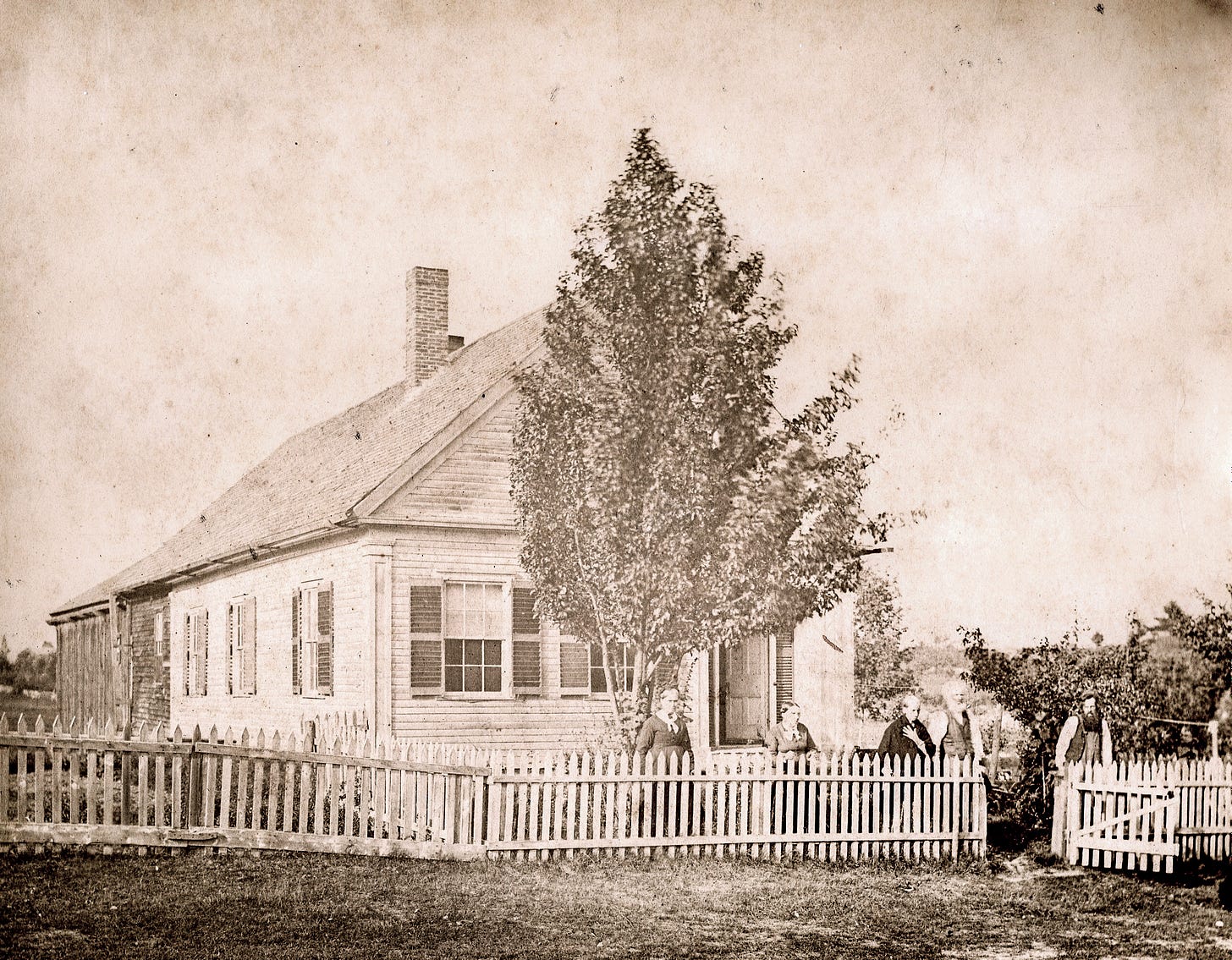 House with picket fence and five people