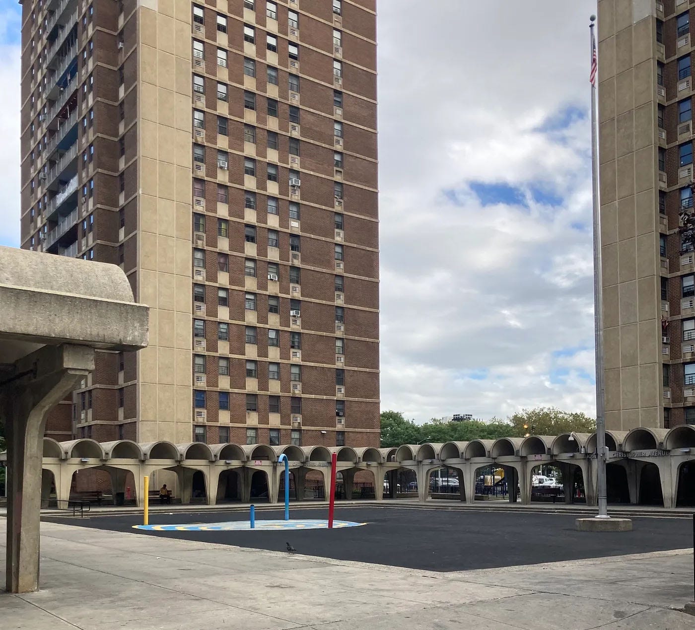 A photo of a concrete courtyard and two large birck apartment buildings.
