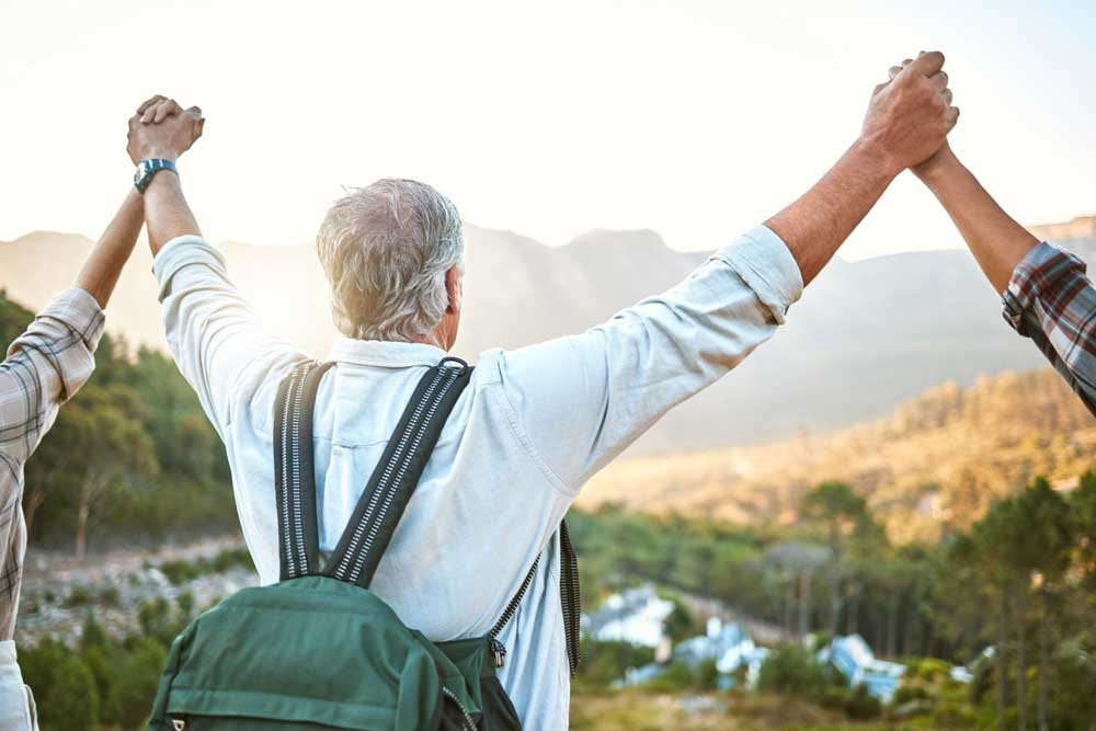 Elder celebrating a hike with friends outdoors.