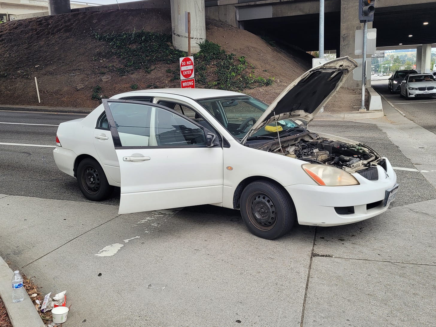 A broken down white 2004 Mitsubishi Lancer ES