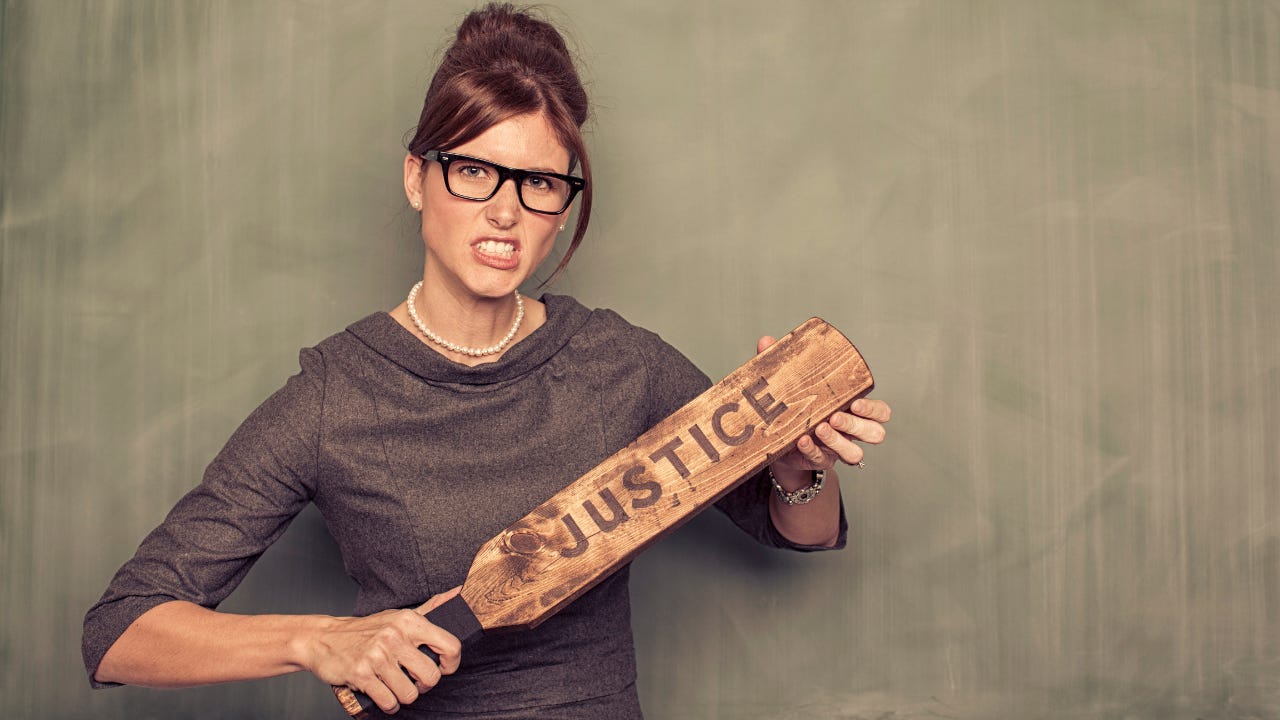 An angry woman holding a paddle that says, "Justice."