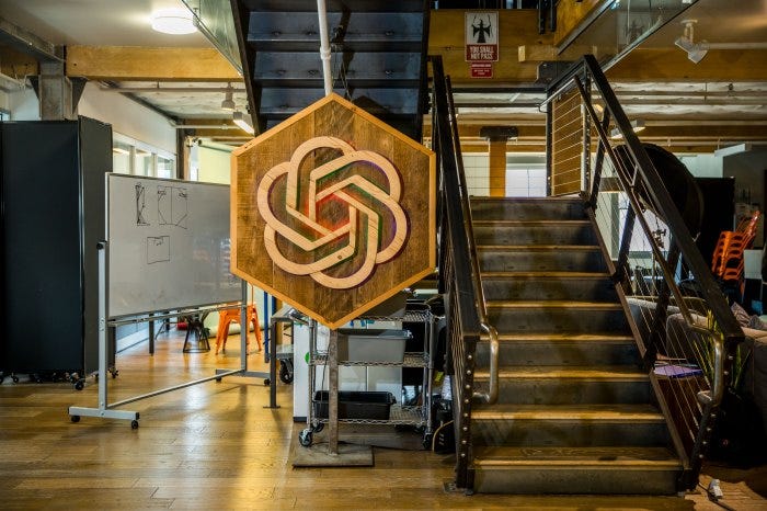 Photograph of OpenAI branded sign in their office space