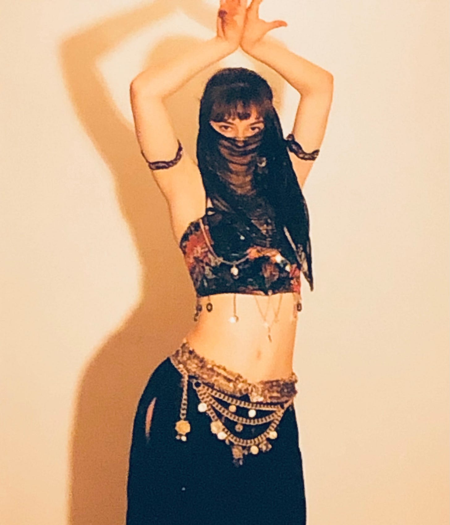 The author vamping at you ever so seriously in a gold and black jingle-bedecked belly dancer costume.