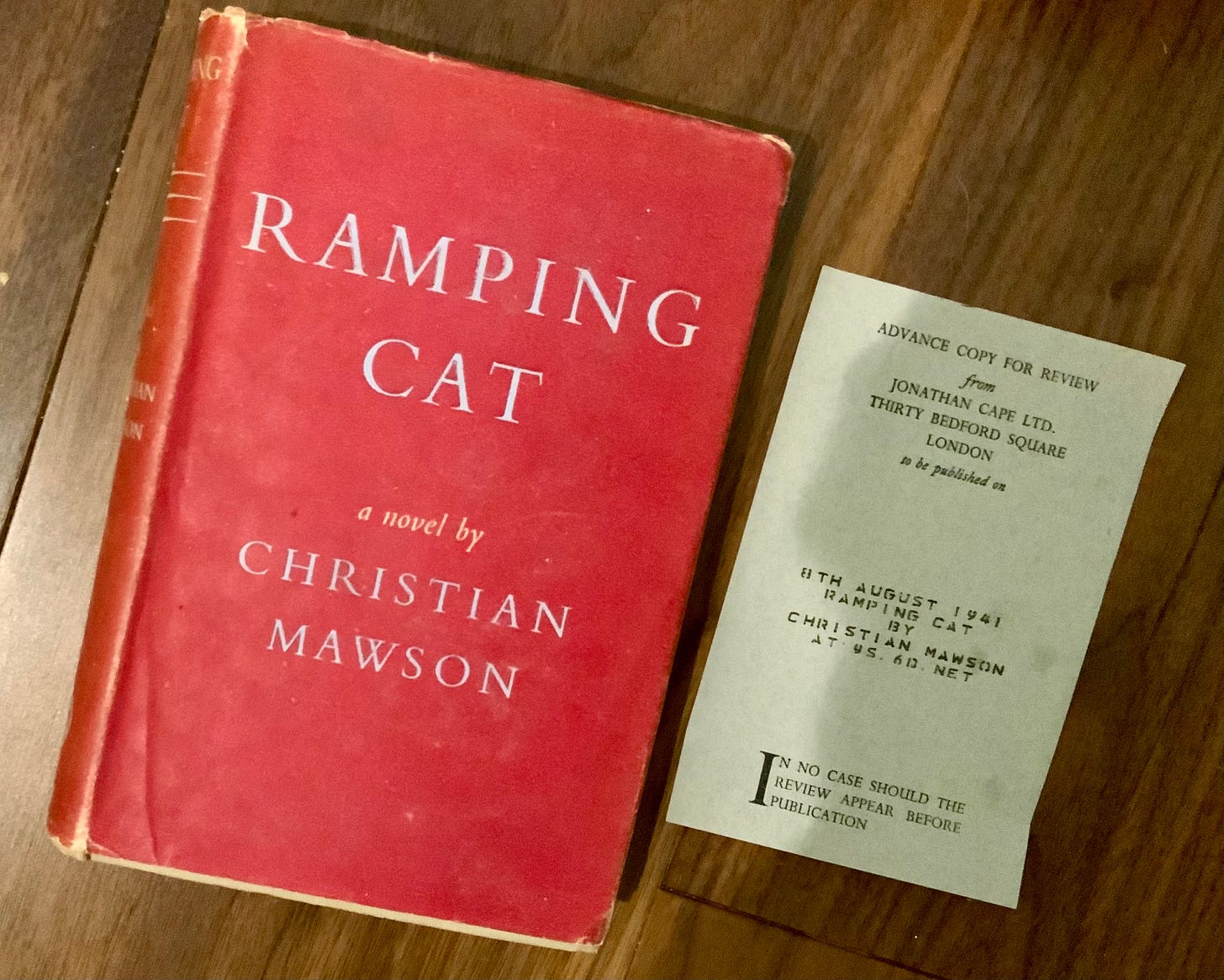 A copy of Ramping Cat in a red dust jacket, a review slip next to it, dated 8 August 1941