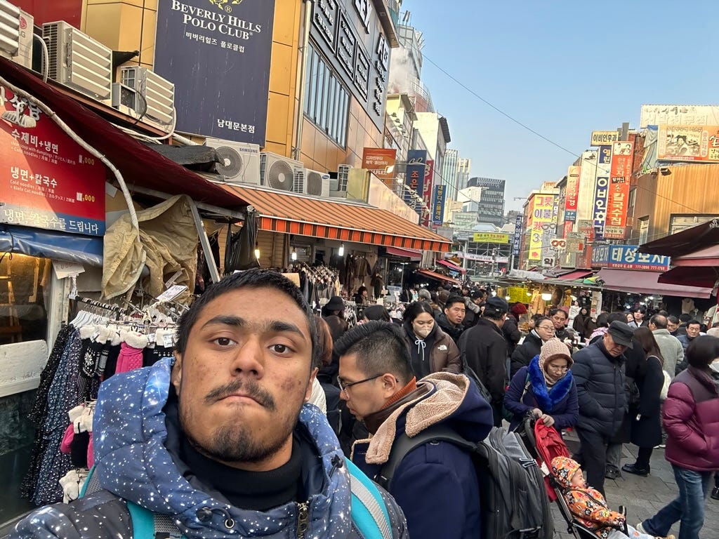 A person taking a selfie in a crowded street

Description automatically generated