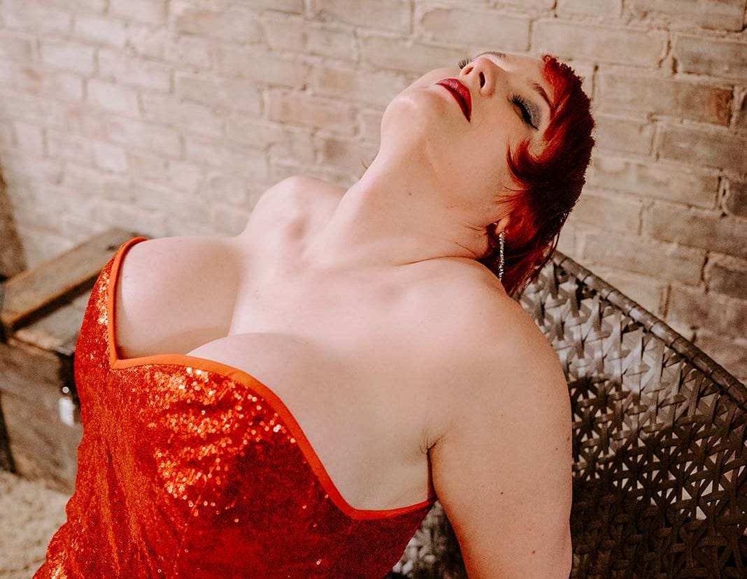 A photo of the author, in a sequined Jessica Rabbit-style dress. Her neck is craned back, exposing very deep cleavage.