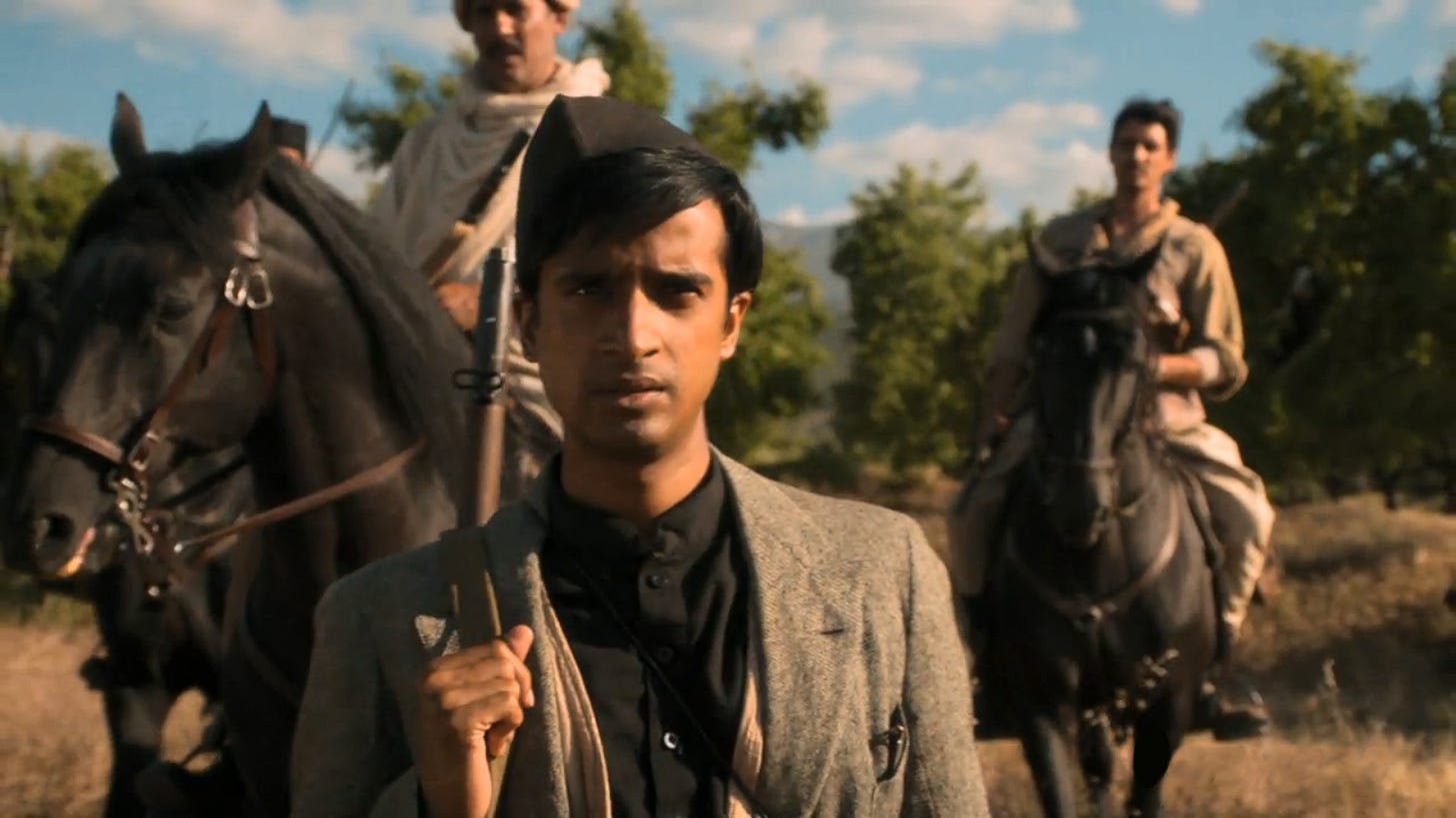 This image shows Manish (played by Hamza Jeetooa) wearing the uniform and rifle of his Hindu nationalist brethren. At the climax of "Demons of the Punjab" (Doctor Who Series 11's sixth episode), Manish stands in front of two fellow, armed nationalists mounted on horseback. This image shows Manish (played by Hamza Jeetooa) wearing the uniform and rifle of his Hindu nationalist brethren. At the climax of "Demons of the Punjab" (Doctor Who Series 11's sixth episode), Manish stands in front of two fellow, armed nationalists mounted on horseback.