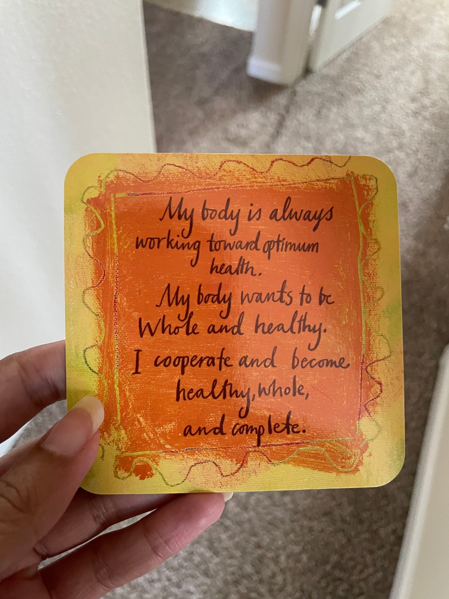 An orange and yellow affirmation card that reads: "My body is always working toward optimum health. My body wants to be whole and healthy. I cooperate and become healthy, whole, and complete."