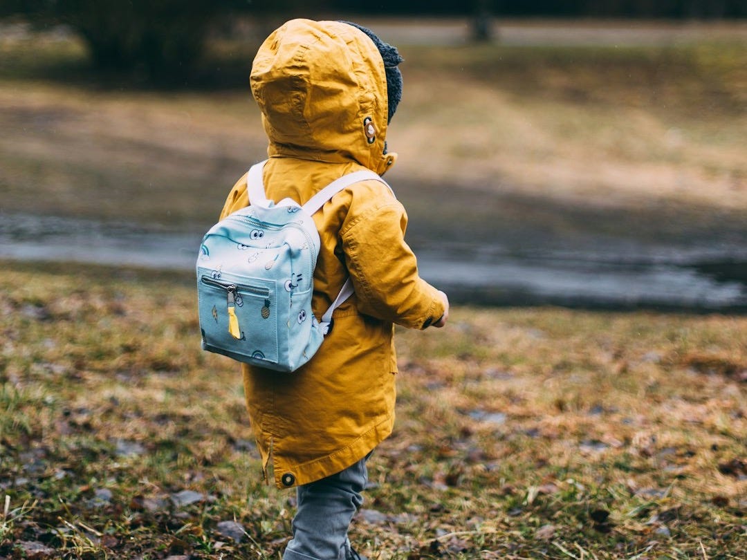 shallow focus photo of toddler walking near river
