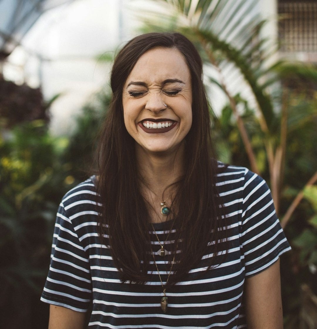 woman smiling while standing in garden