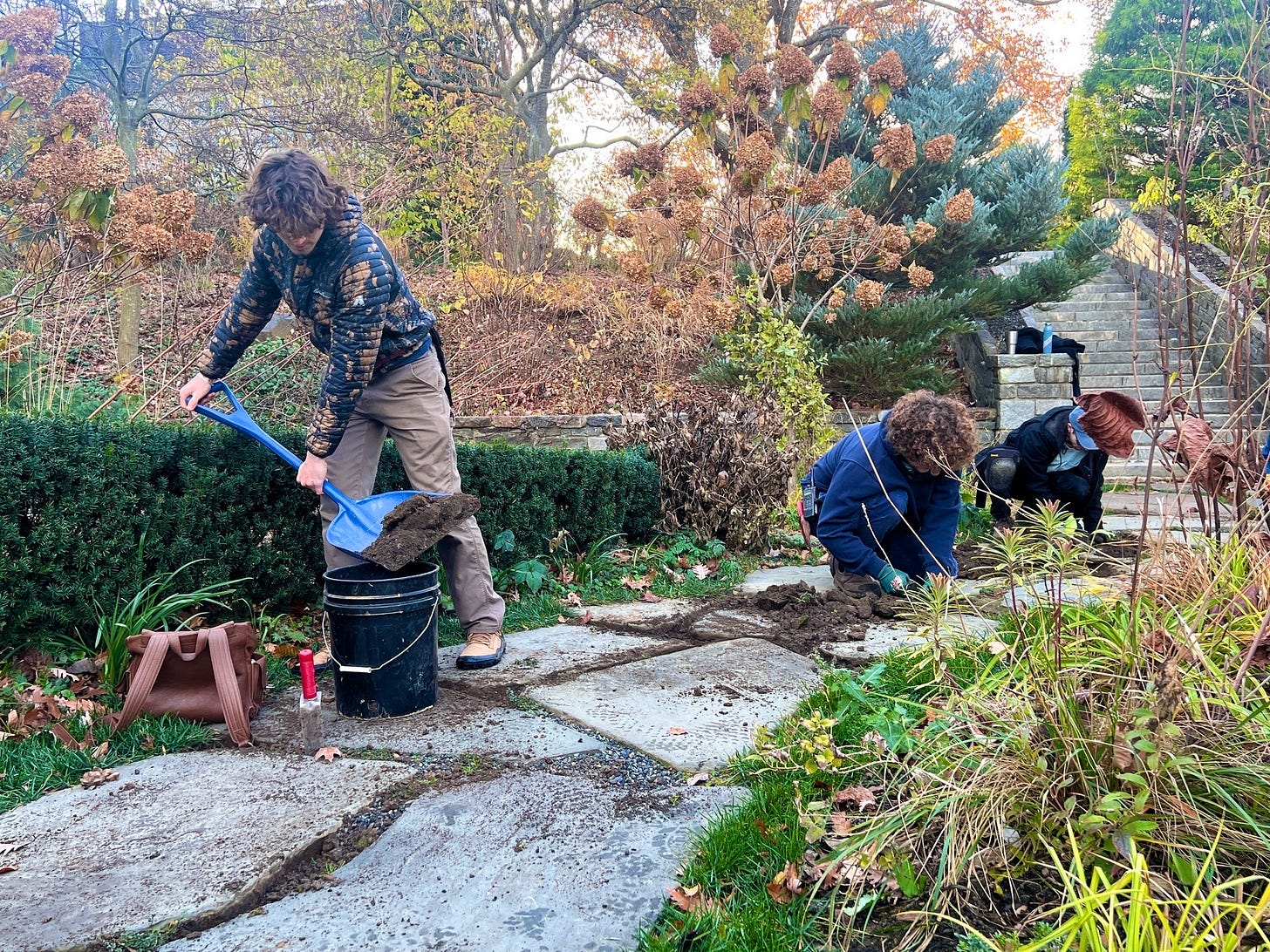 Noah shovels compost into the cracks on a path at Chanticleer Gardens. Photo by Lisa Roper