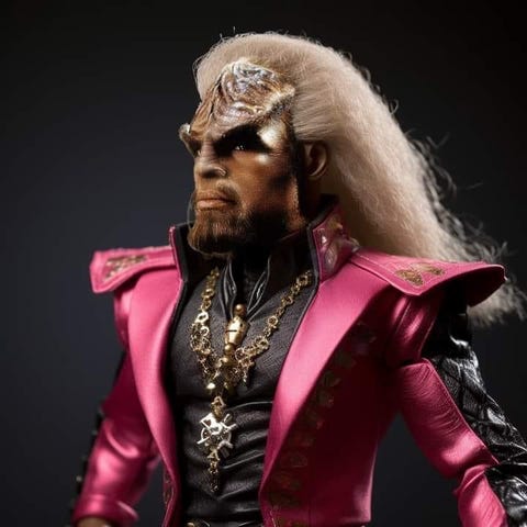 An image of Star Trek's Klingon Worf dressed as Barbie with a pink leather coat and long flowing blonde hair. Titled "You haven;t really seen Barbie until you see it in the original Klingon," a reference to Star Trek 6 line “You have not experienced Shakespeare until you have read him in the original Klingon.”