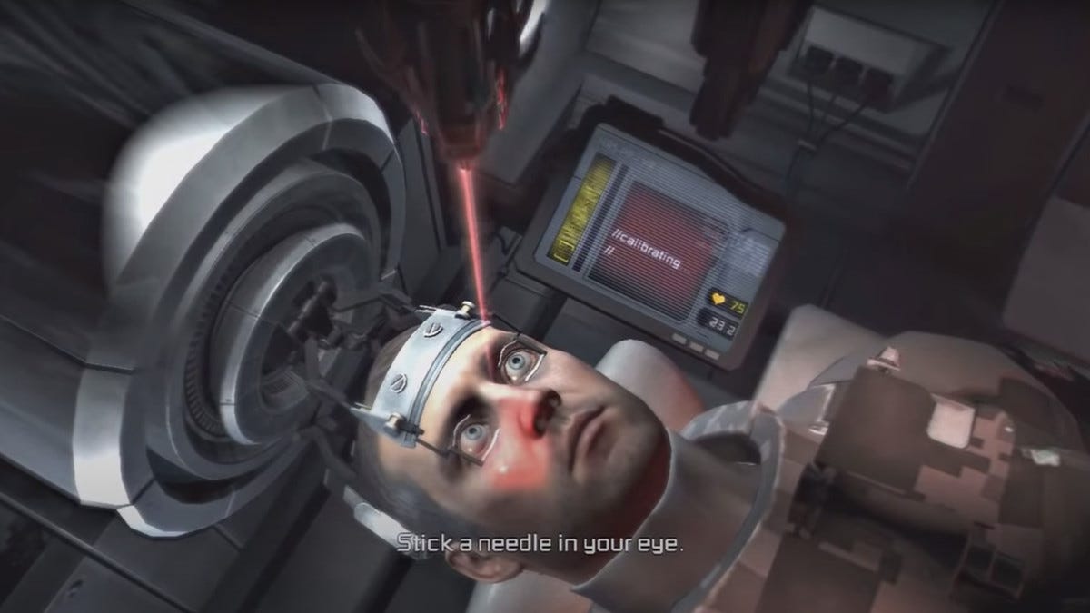 A screenshot from Dead Space 2, which features the protagonist strapped into a medical looking apparatus. Their eyes are being held open by wires. There is a robotic arm in front of them with a lazer site. The text prompt at the bottom of the screen reads "stick a needle in your eye" 