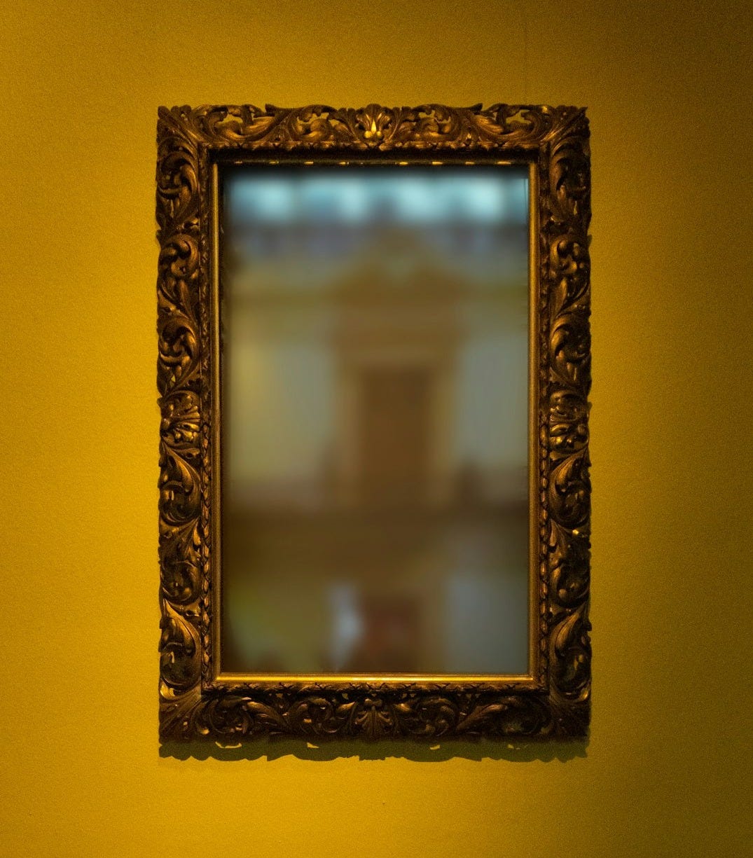 rectangular leaning mirror with brass-colored frame