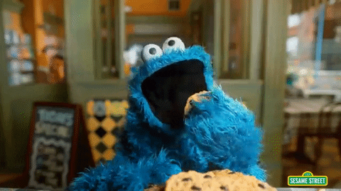 Gif of Sesame Street character Cookie Monster messily eating cookies. It starts with Cookie Monster making googley eyes and then cuts to the cookie eating, shifting into cinematic slo-mo.