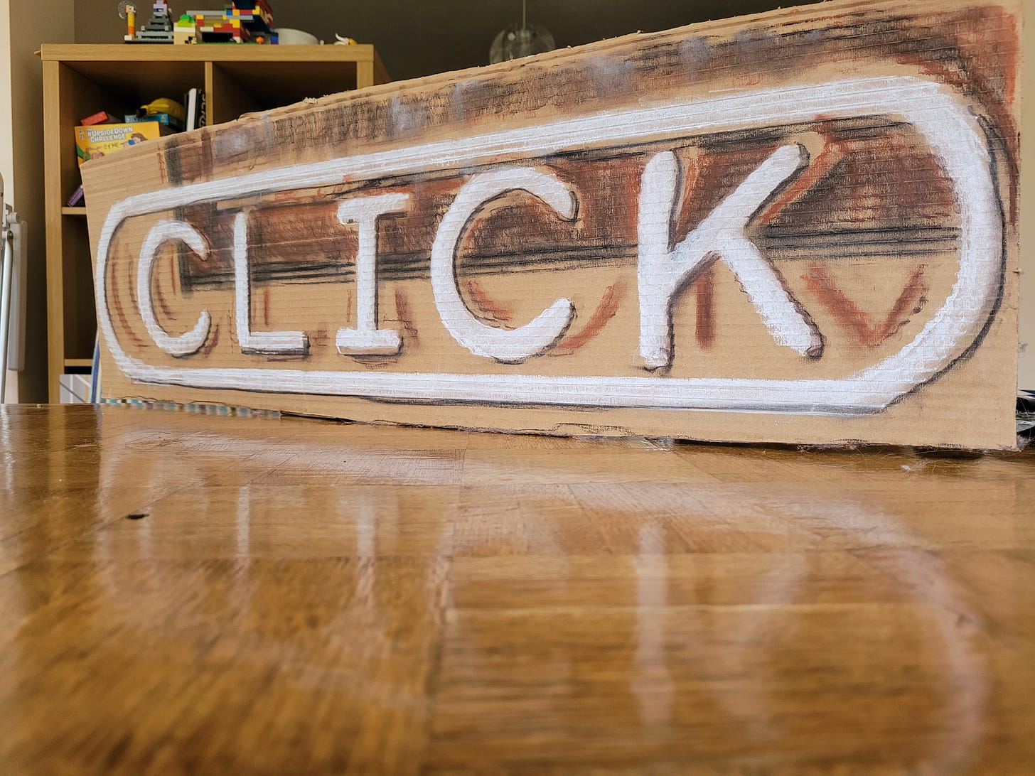 A chalk-on-cardboard copy of the Click logo