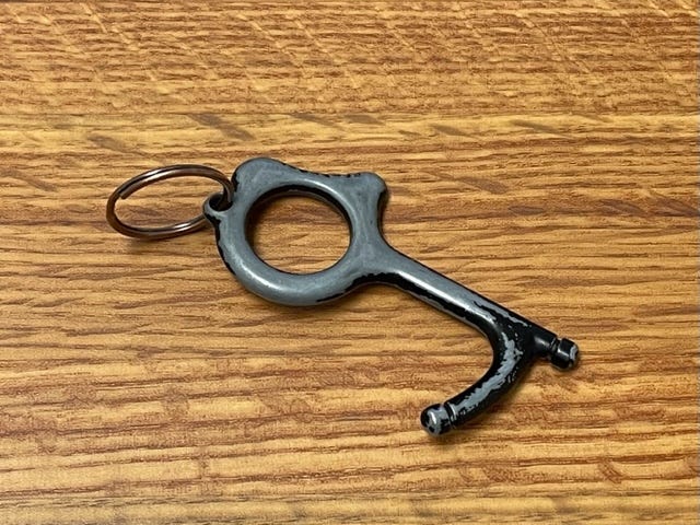 A worn keyring that can be used to pull open doors without touching the handle with your skin