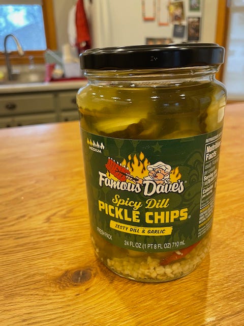 A jar of Famous Dave's Spicy Dill Pickle Chips on a kitchen counter