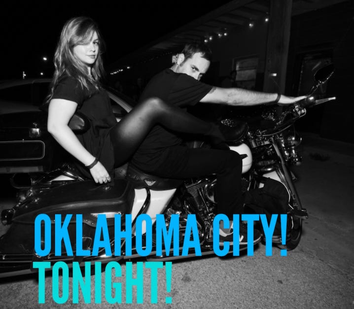 Amber and Derrick pose on a parked motorcycle. Derrick is in the driver's seat with his hands on the handlebars. Amber sits behind him with her legs wrapped around his torso. Text on the image reads "Oklahoma city! Tonight!"
