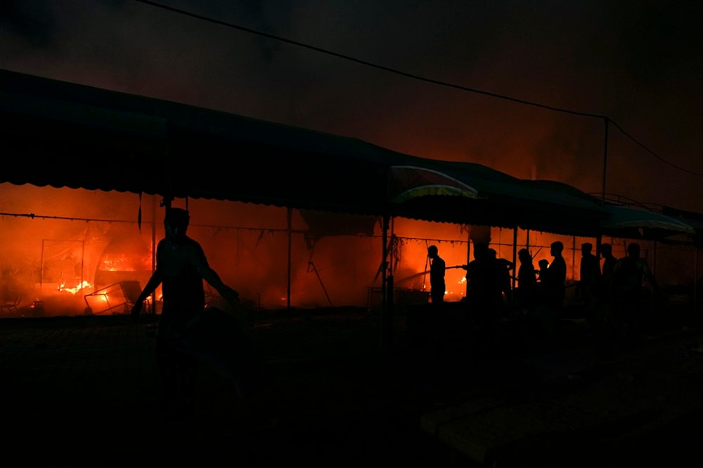 Palestinians try to extinguish a fire caused by an Israeli strike that hit a tent area in the courtyard of Al Aqsa Martyrs hospital in Deir al Balah, Gaza Strip, Monday, Oct. 14, 2024. (AP)