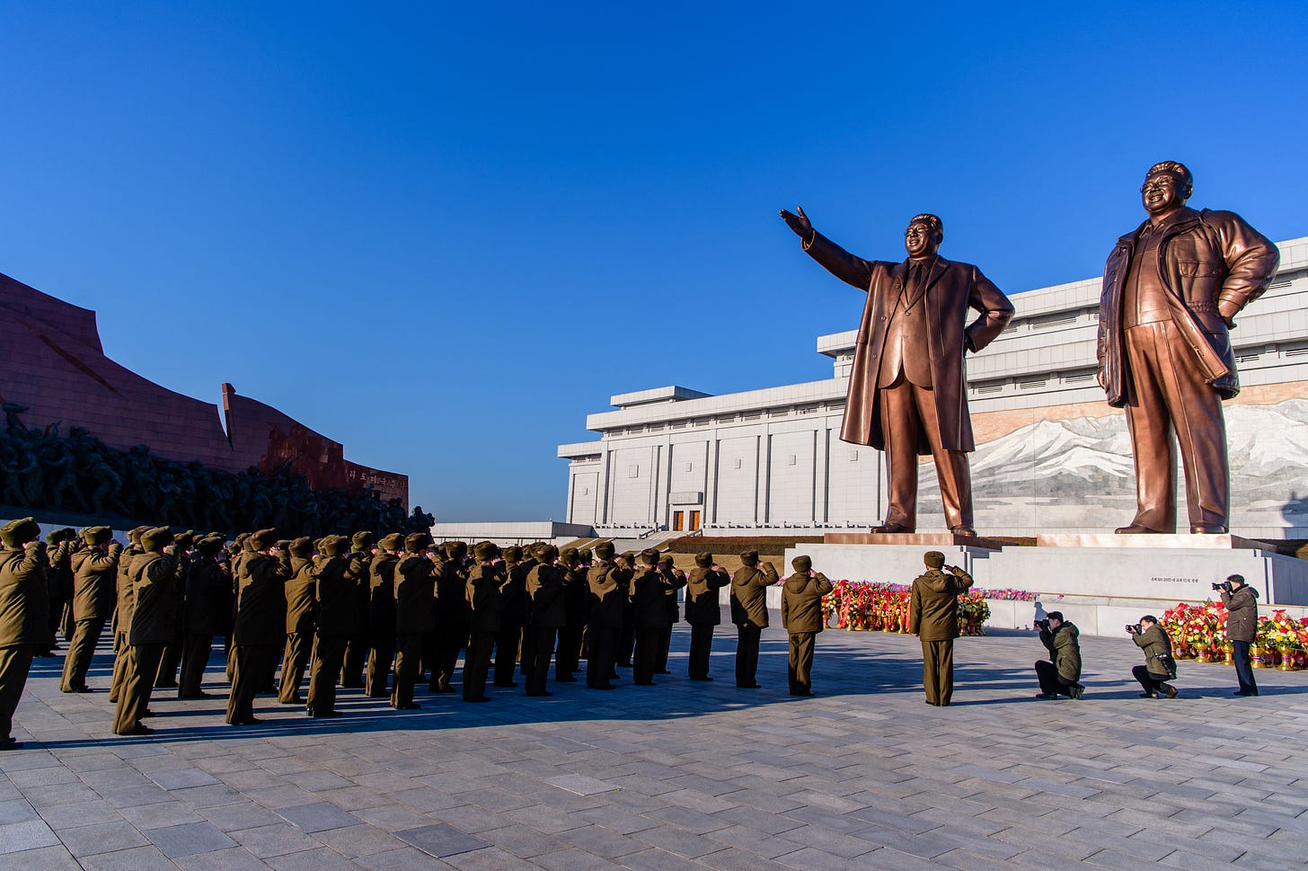 North Koreans visit statues of late North Korean leaders Kim Il-Sung and Kim Jong-Il, February 16, 2024. (Photo by KIM Won Jin/AFP.)