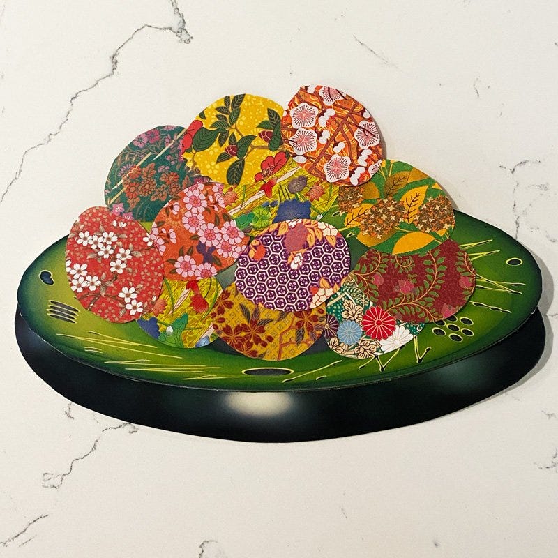 Collage by Helen Sword of a green bowl containing a pile of colourful eggs in different designs.