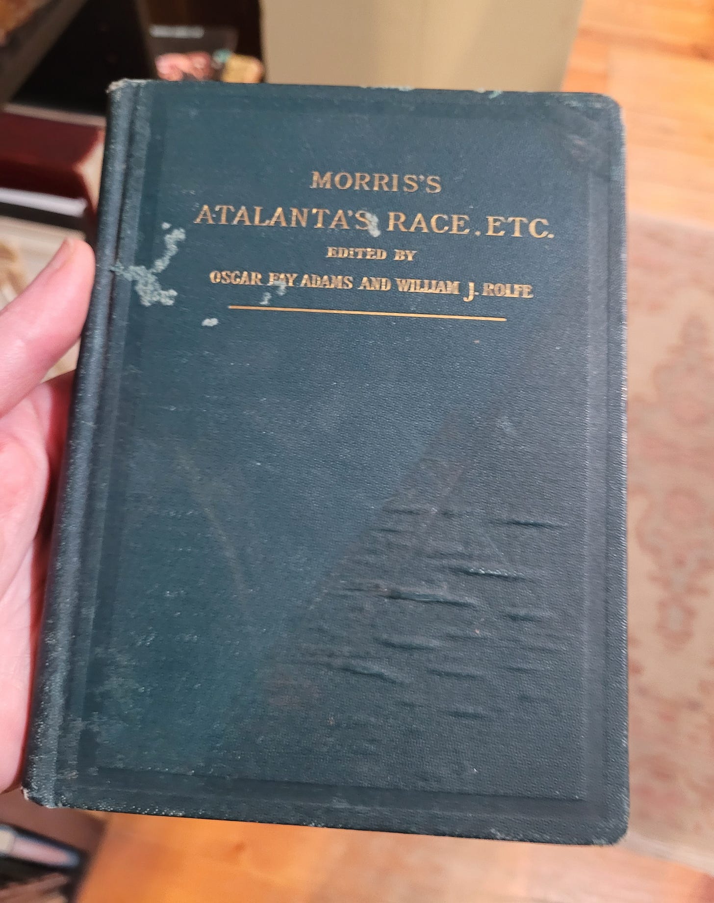 photo of an old green copy of atalanta's race by william morris. the title is printed in gold on a greenish hardcover