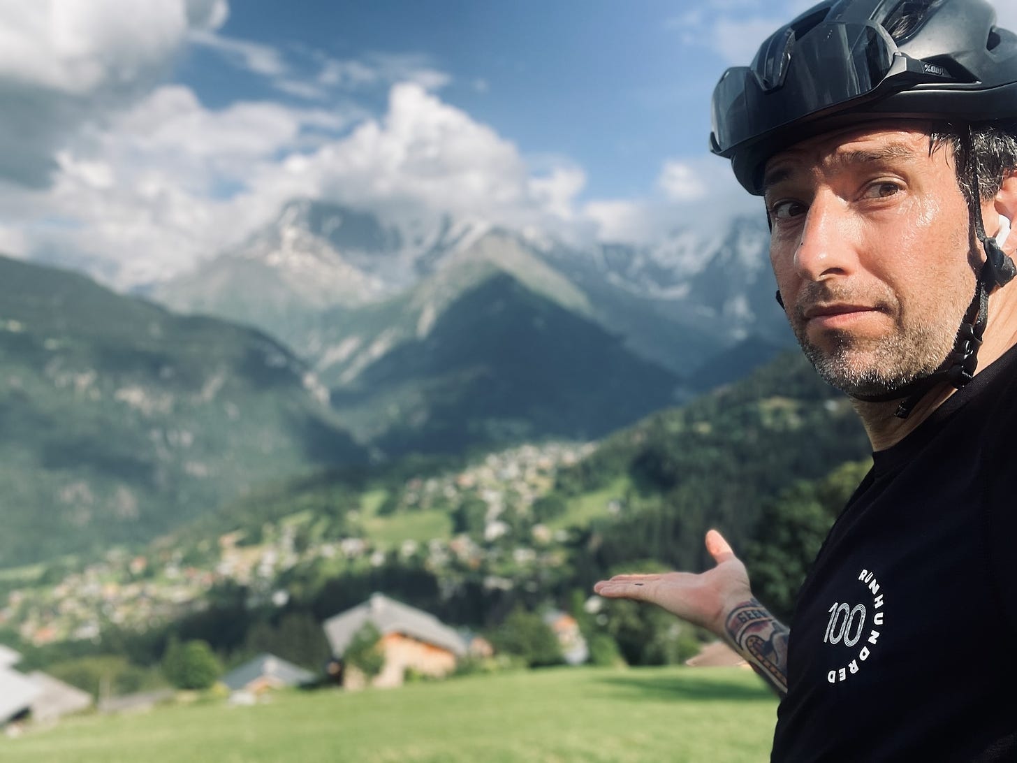 the author pointing at a mountain range in the background