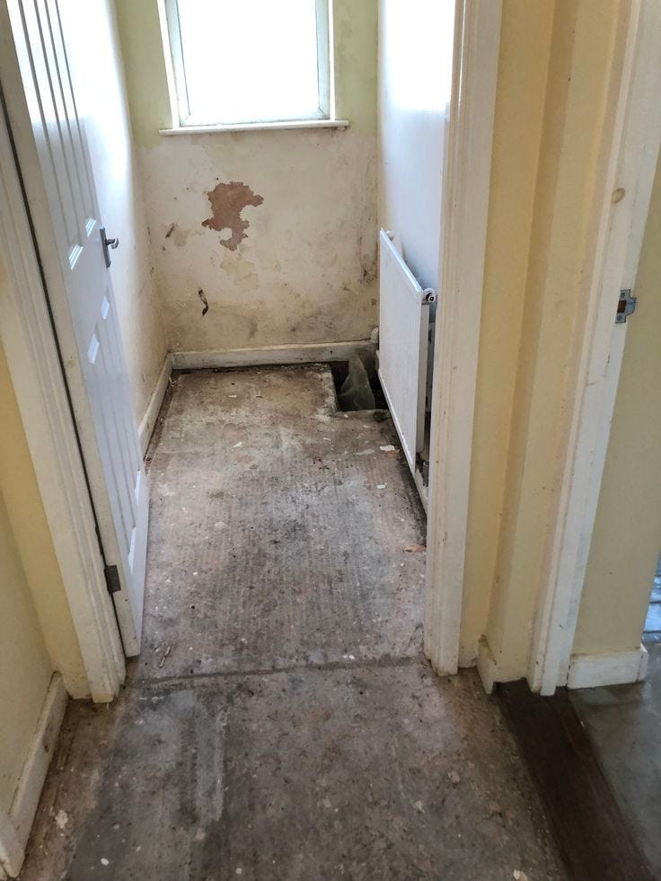 This may contain: an empty room with dirty floors and no one on the door or window sill