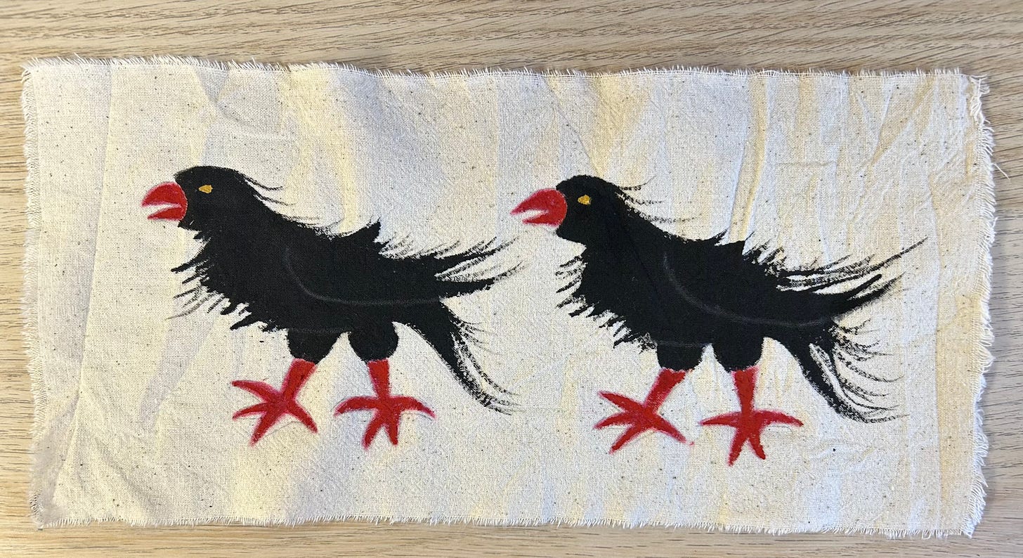 Two black birds with red beaks and feet, painted on to calico