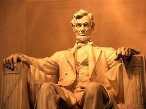A statue of a person sitting in a chair with Lincoln Memorial in the background

Description automatically generated