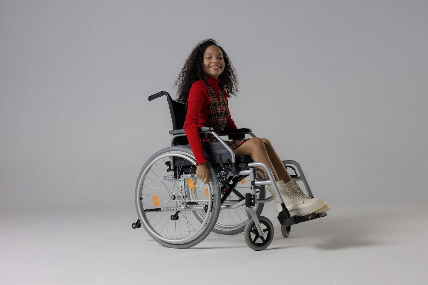 Smiling woman wearing red top sitting in a wheelchair