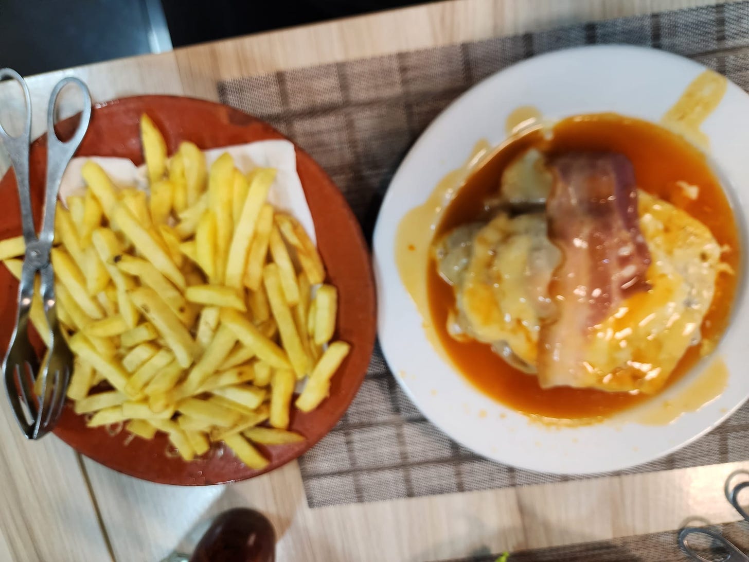 Blurry photo I took previously of a Francesinha and fries.