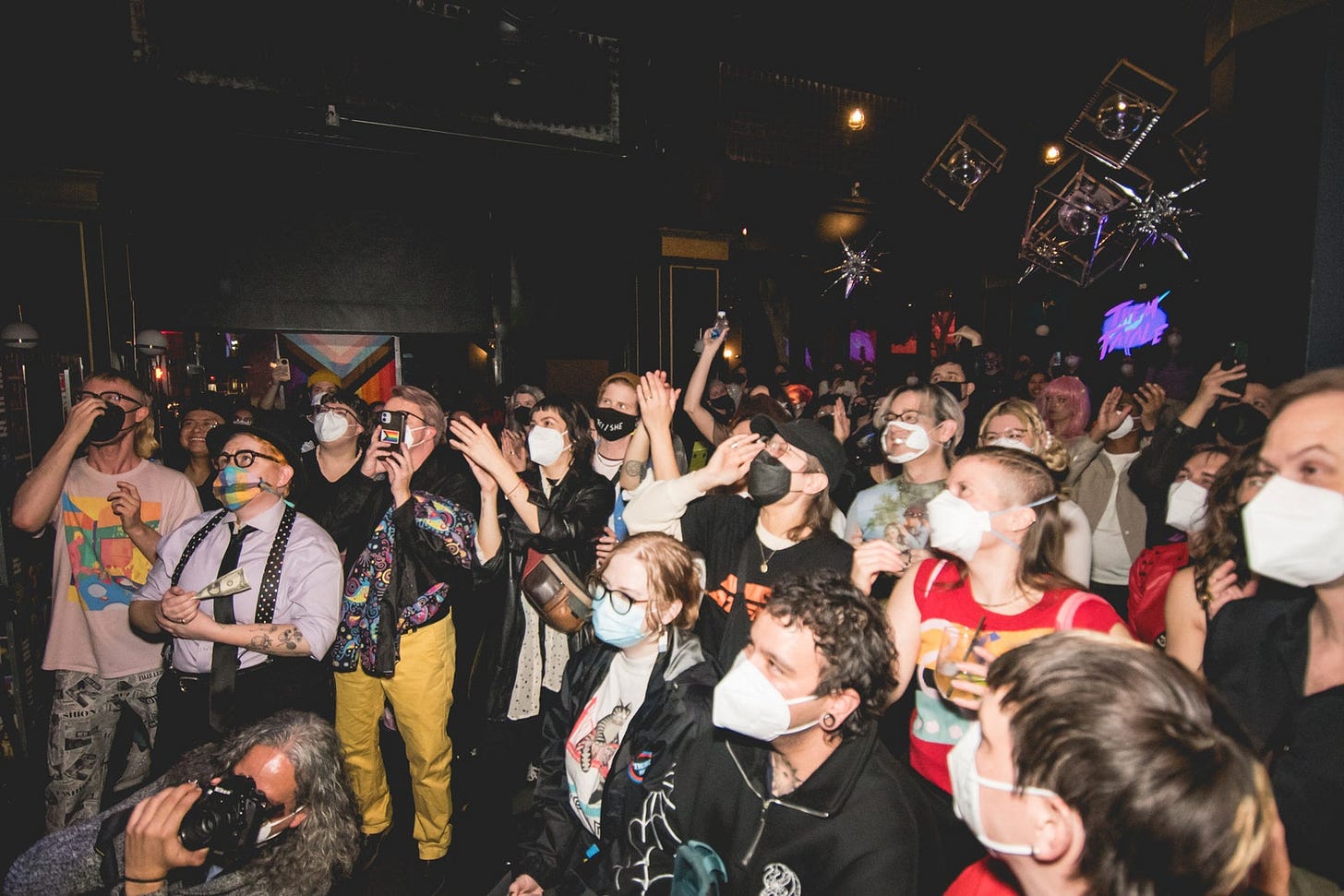 In a club space, everyone in the audience is wearing a mask, and almost everyone has a high-quality one like KN95s.